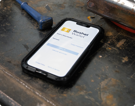 Bushel Wallet app on a phone on a shop workbench